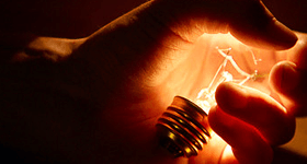 Glowing light bulb in a hand