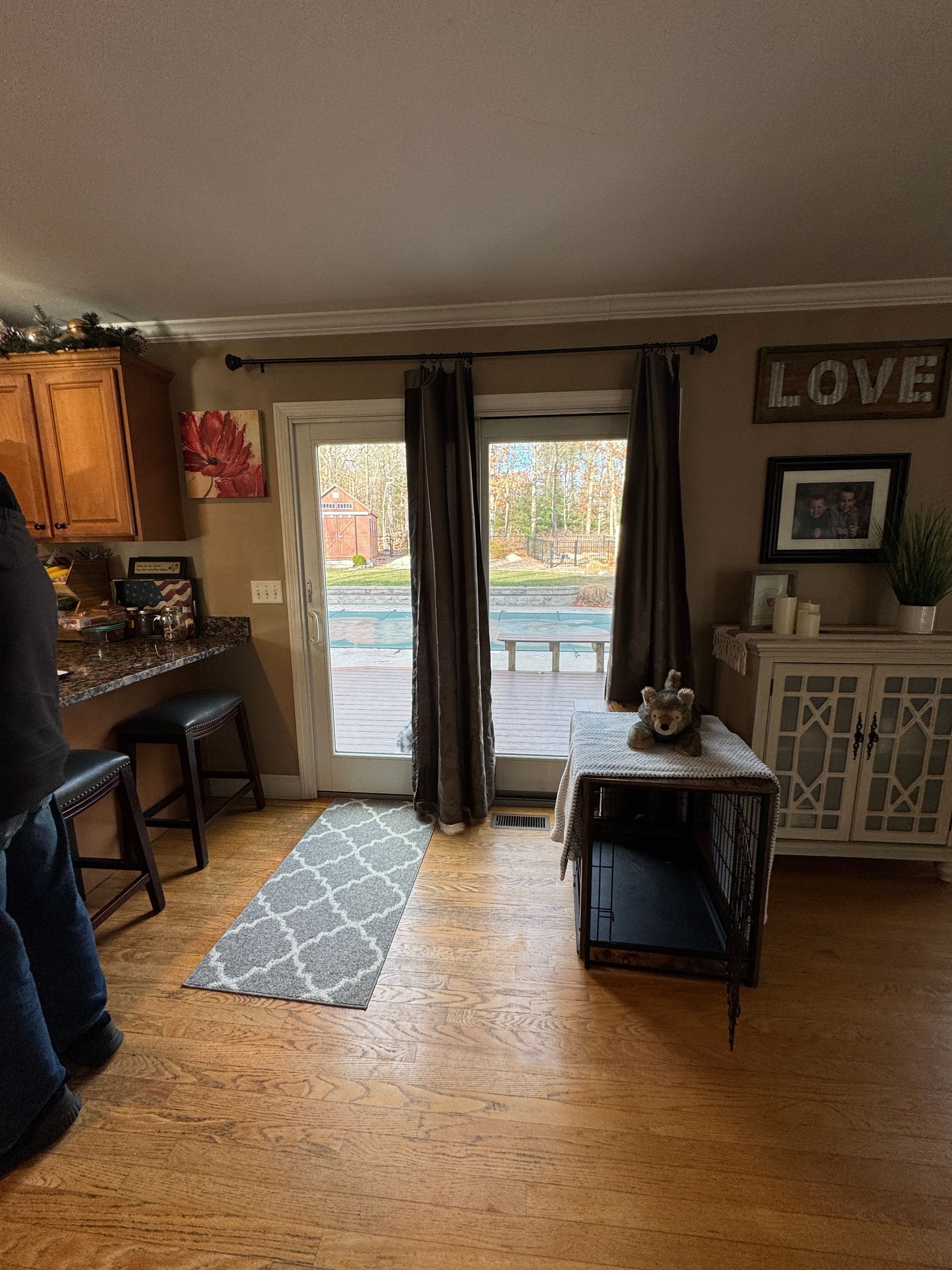 Cozy kitchen and dining nook with sliding glass door, small table, rug, and “LOVE” wall sign.