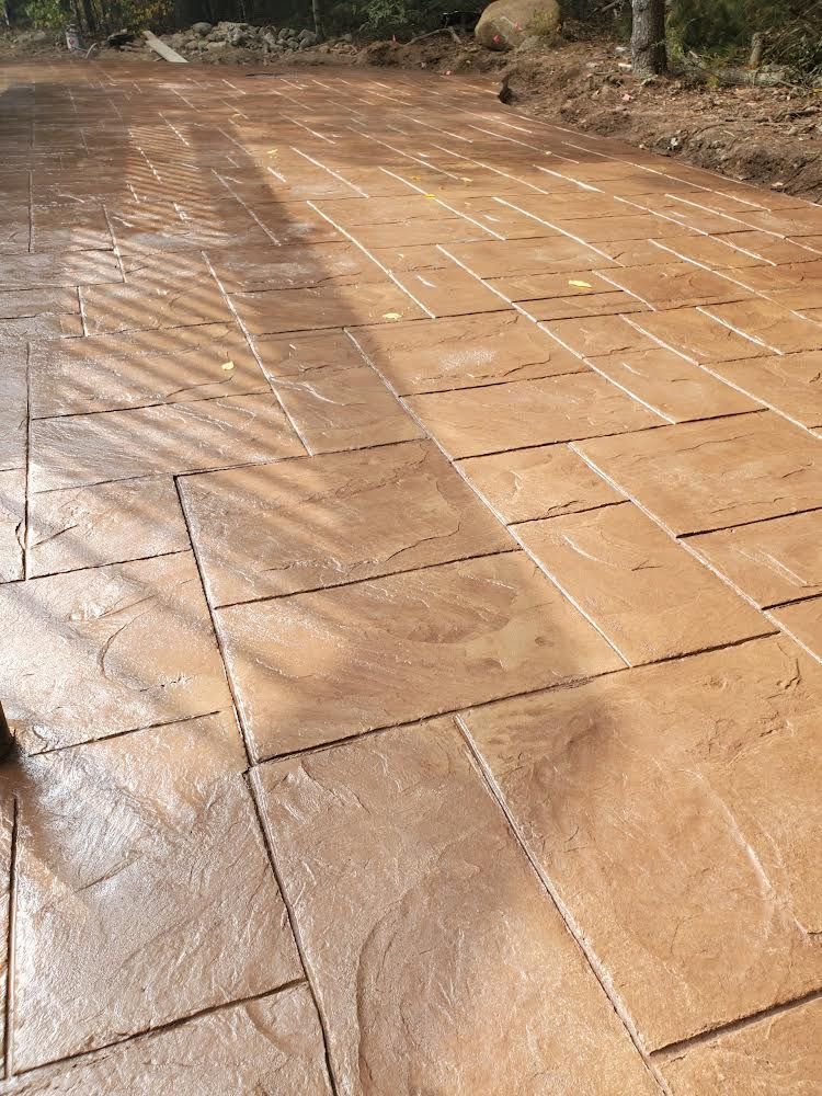 Wet tan tiled walkway outdoors with water flowing across the surface
