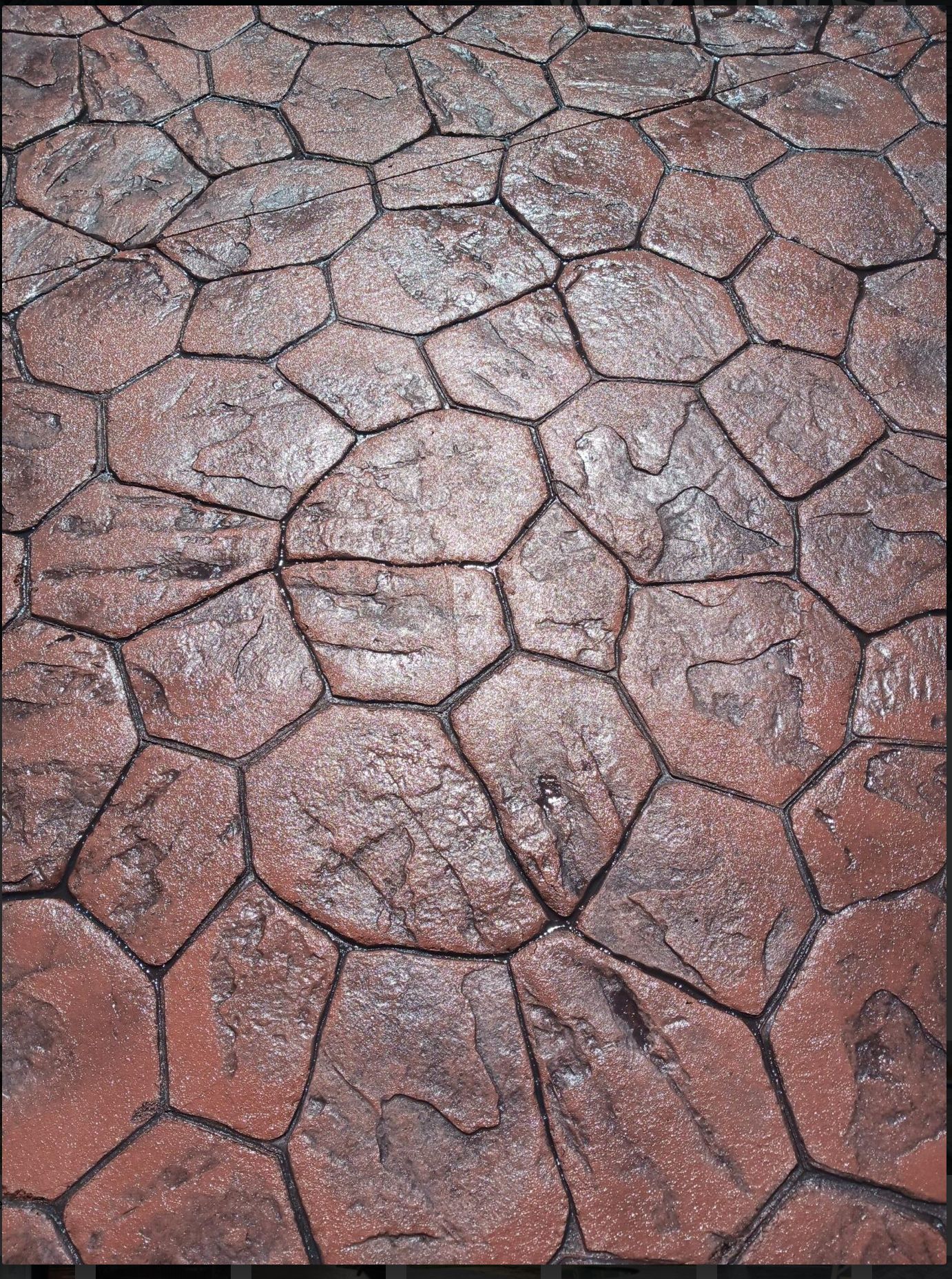 Textured reddish-brown cracked stone pavement pattern