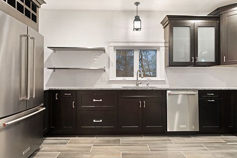 Kitchen with dark brown cabinets, stainless steel appliances, and gray tile floor.