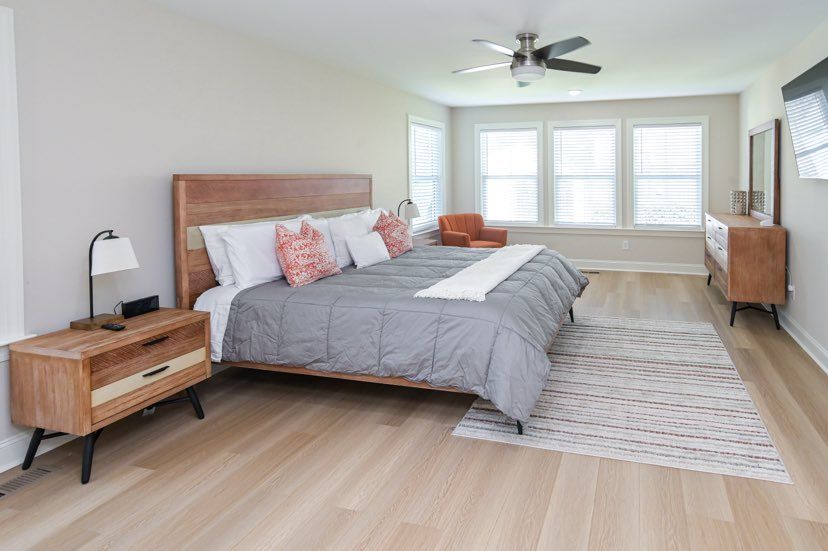 A bedroom with a king size bed, nightstands, and a ceiling fan.