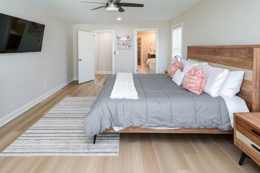 A bedroom with a king size bed and a flat screen tv on the wall.