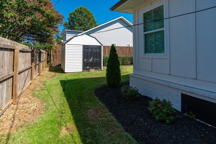 There is a shed in the backyard of a house.