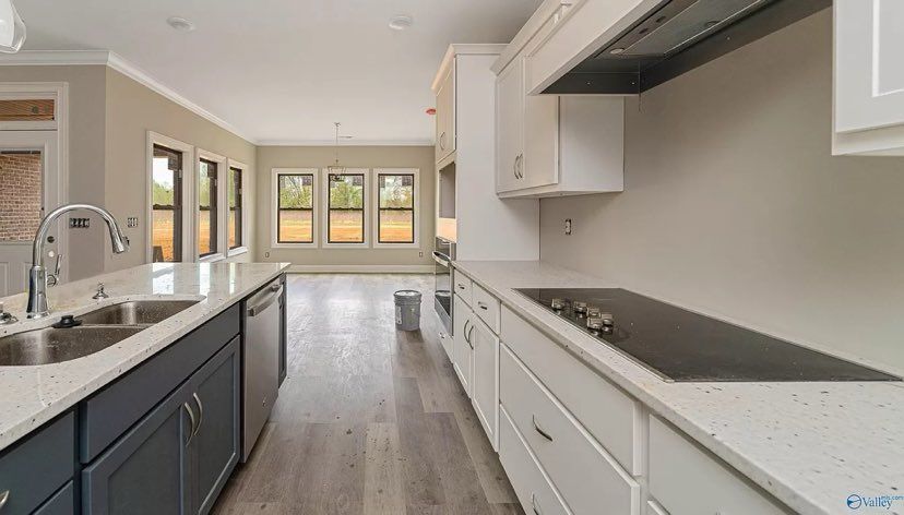 A kitchen with a stove top oven, sink, and dishwasher.
