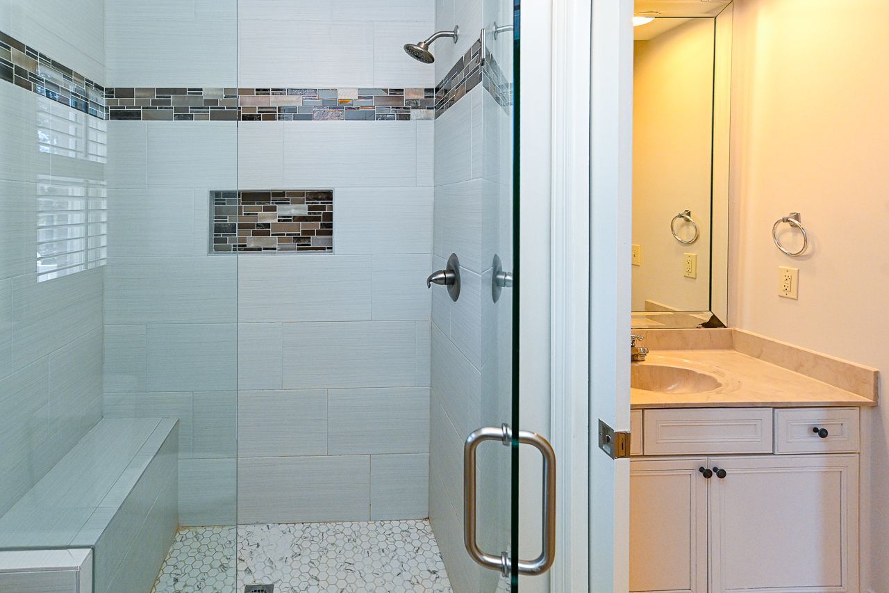 A bathroom with a walk-in shower and a sink.
