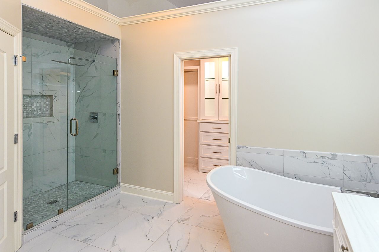 A bathroom with a tub and a walk in shower.