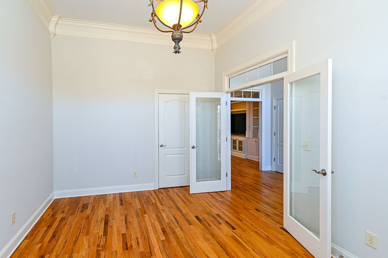 An empty room with hardwood floors and white walls.