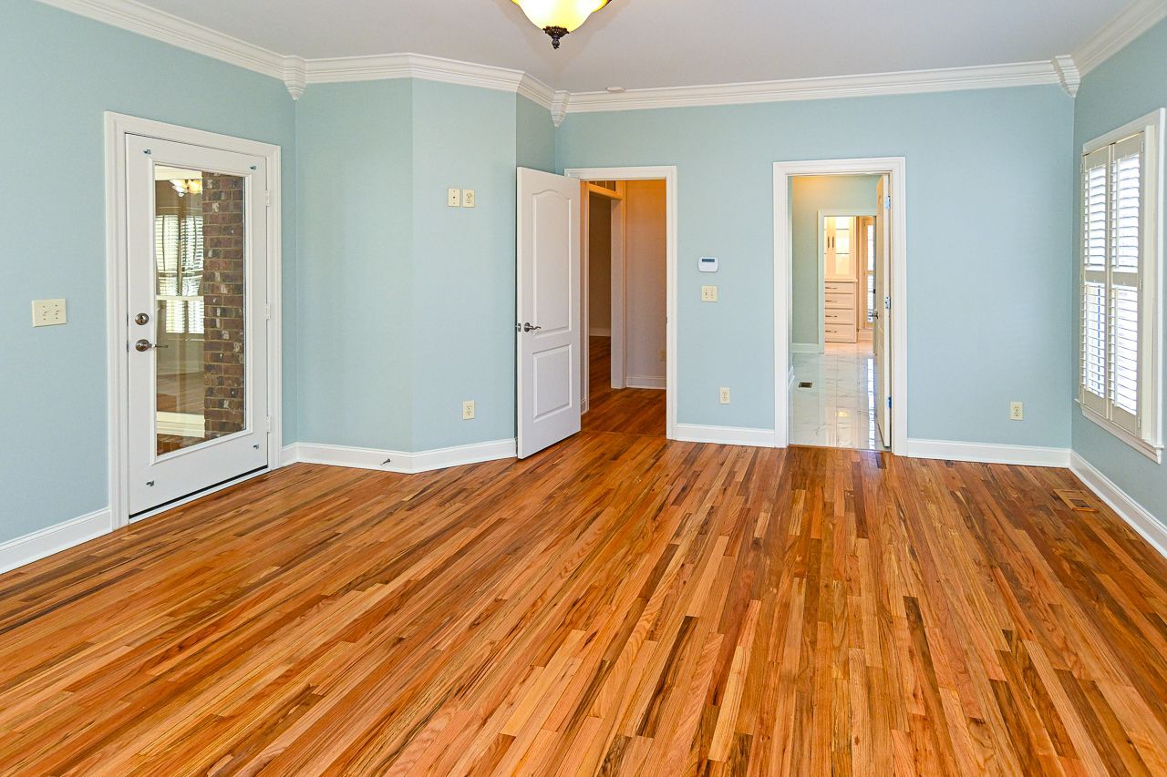 An empty room with hardwood floors and blue walls.
