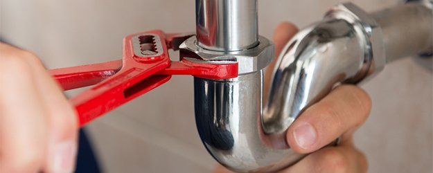 Plumber fixing pipe with Wrench