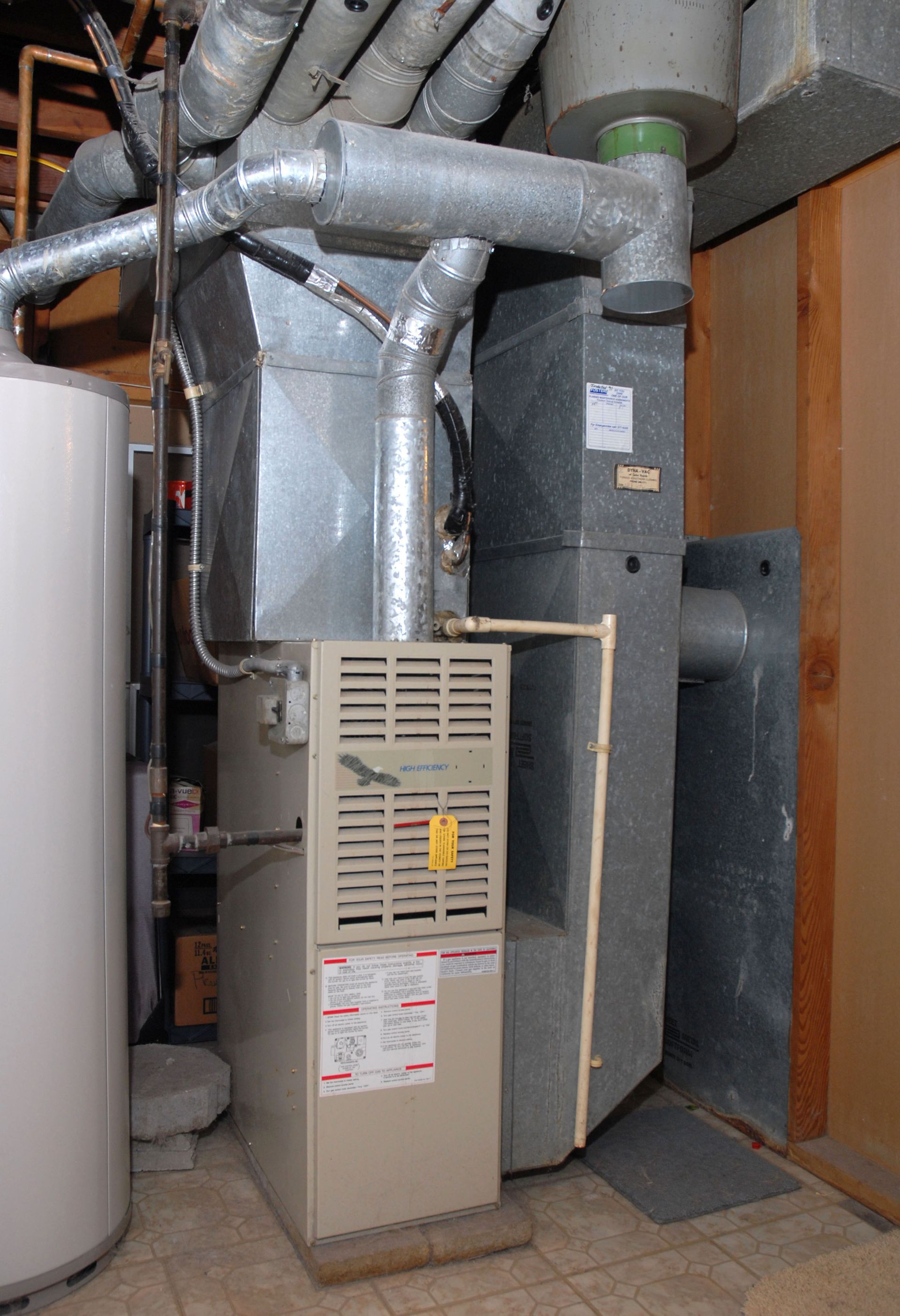 Furnace and hot water tank in a basement; ductwork visible; neutral colors.