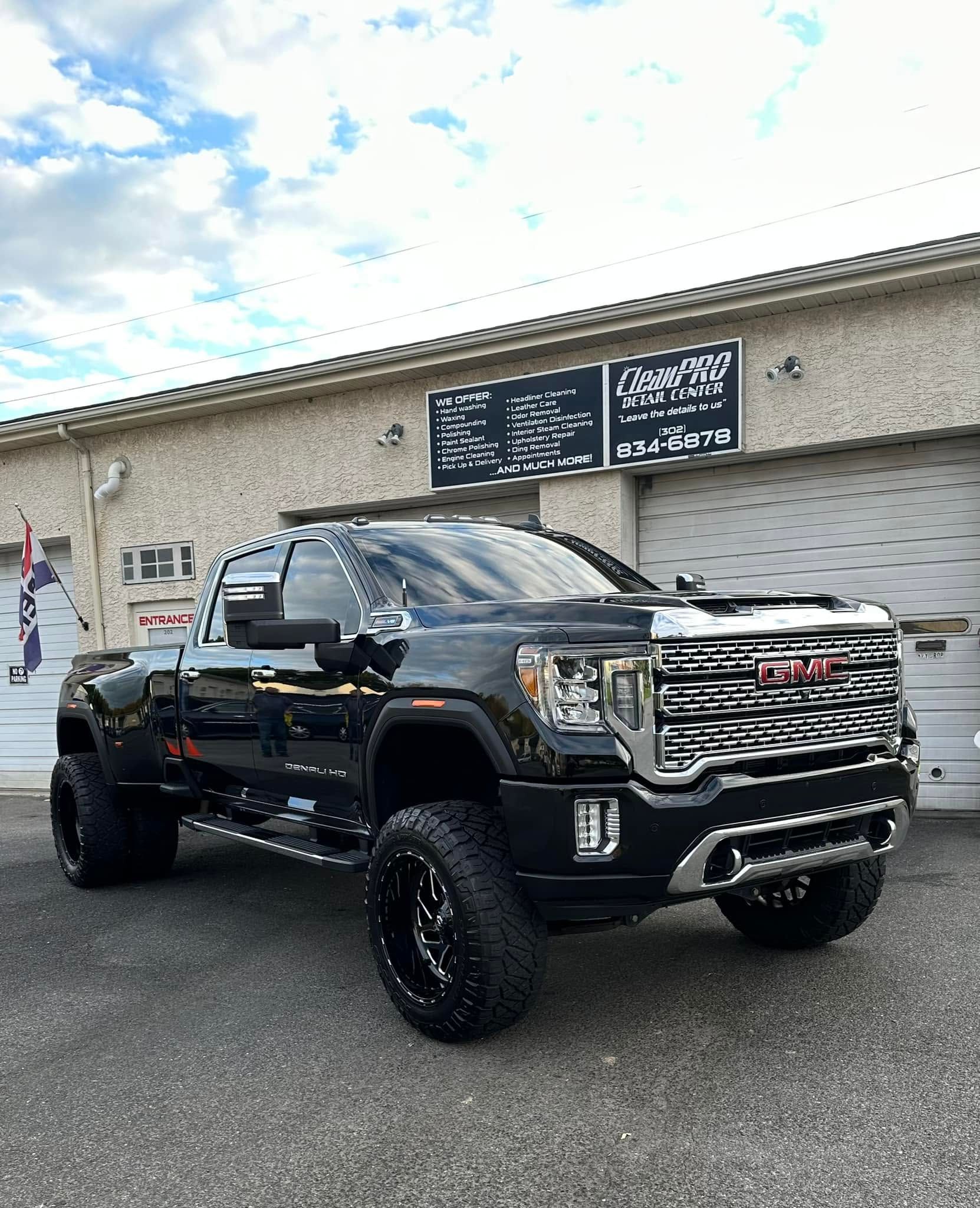 Black lifted pickup truck parked outside a building