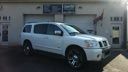 White SUV parked in a dim garage with a blue truck in the background