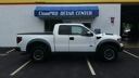White pickup truck parked outside a community center building.