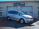 Silver minivan parked in front of a beige building with garage doors