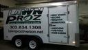 White moving truck with “Dawn Pro…” logo and phone number parked at night.