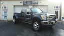 Black lifted pickup truck parked outside a building with garage doors