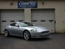 Silver sports car parked in front of an auto shop garage