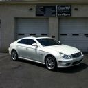 Silver coupe parked in front of a garage door under a building overhang
