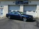 Blue sedan parked in front of a service garage with closed white doors