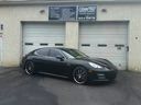 Black sports car parked outside a beige garage door