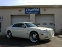 Silver sports coupe parked in front of a garage with an open bay