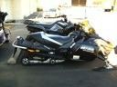 Black-and-silver snowmobile parked indoors on display, side view