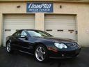 Black sports car parked in front of a garage door with a Close Pro sign above it