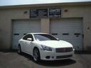 White sedan parked in front of a gray garage door