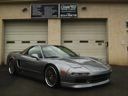 Dark gray sports car parked in front of beige garage doors