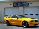 Yellow sports car parked in front of a gray garage door