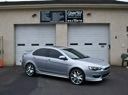 Silver sedan parked in front of a building with two garage doors