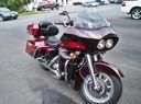 Red touring motorcycle parked on a street with cars in the background