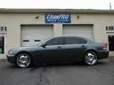 Black sports coupe parked in front of a garage with a sign above the door