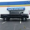 Black lifted pickup truck parked in front of a Dream Center building with blue and yellow trim
