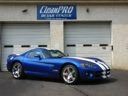 Blue sports car parked outside a garage with a CleanPRO sign above the door