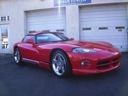 Red sports car parked outside a building at dusk