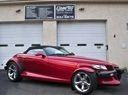 Red sports car parked in front of a garage door with a sign above it.