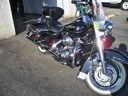 Two chrome motorcycles parked side by side at night