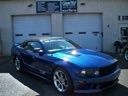 Blue sports car parked in front of a garage door