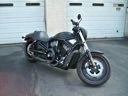 Black cruiser motorcycle parked in front of white garage doors