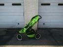 Bright green stroller on a street beside a garage door