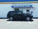 Black SUV parked outside a blue building labeled 
