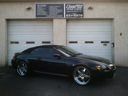 Black sports car parked in front of a garage with two white doors