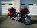 Red touring motorcycle parked on a driveway in front of a garage