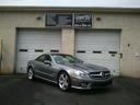 Silver sedan parked in front of two white garage doors