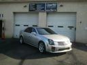 Silver sedan parked in front of a building with two garage doors