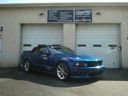 Blue sports car parked in front of a garage with two white doors