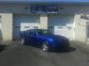 Blue car parked in front of a building with garage doors