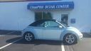 Silver car parked in front of a blue building with a sign reading 